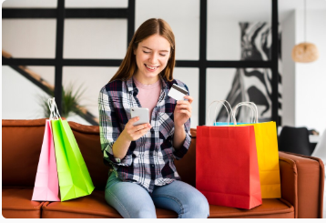 A shopper holding shopping bags and a payment card
